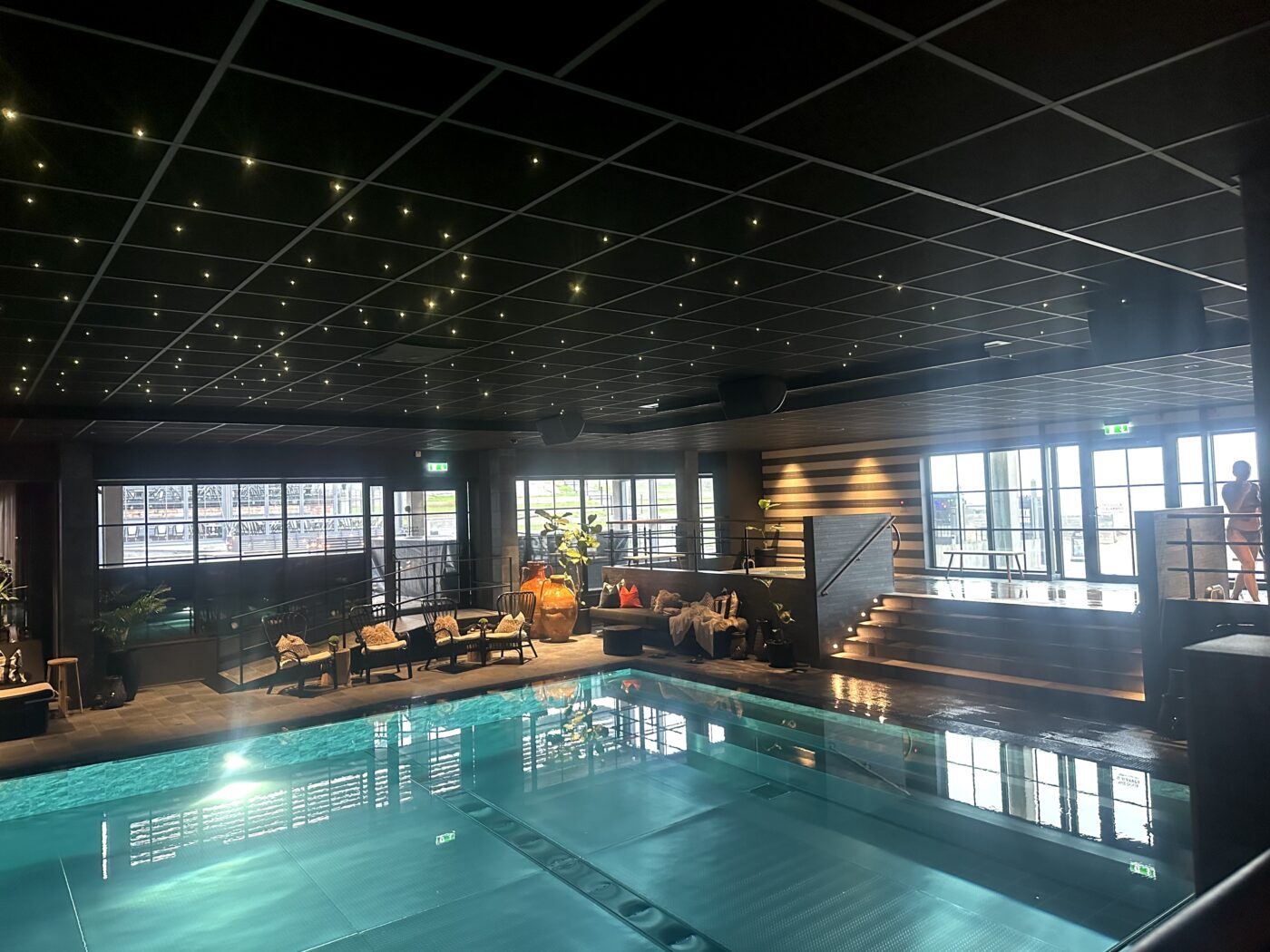 En bild på den stora inomhuspoolen på Tylösand. En bubbelpool syns i bakgrunden samt vilstolar. 